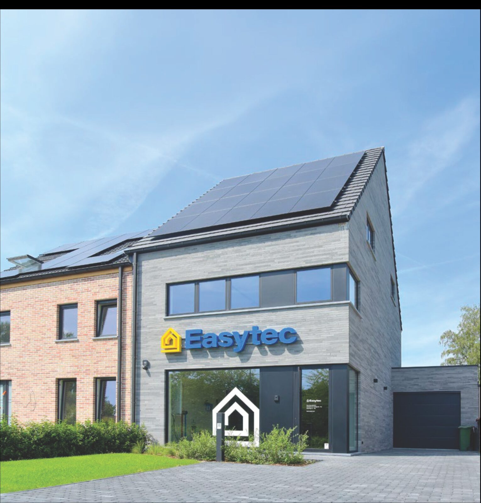 Het gebouw van Easytec Zelfbouw aan de Moorselbaan in Aalst, met zonnepanelen op het dak